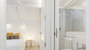 Une chambre à coucher avec un lit, une table de chevet et une lampe.