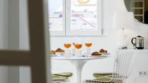 Un coin repas avec une table ronde mise pour le petit-déjeuner, comprenant des croissants et des verres pour le jus d’orange.