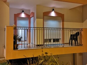 Enjoy the view from this balcony with a chair and potted plant, overlooking the interior space below.