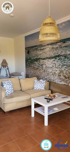 Relax in this stylish living room with a sofa, coffee table, and unique wall hanging.