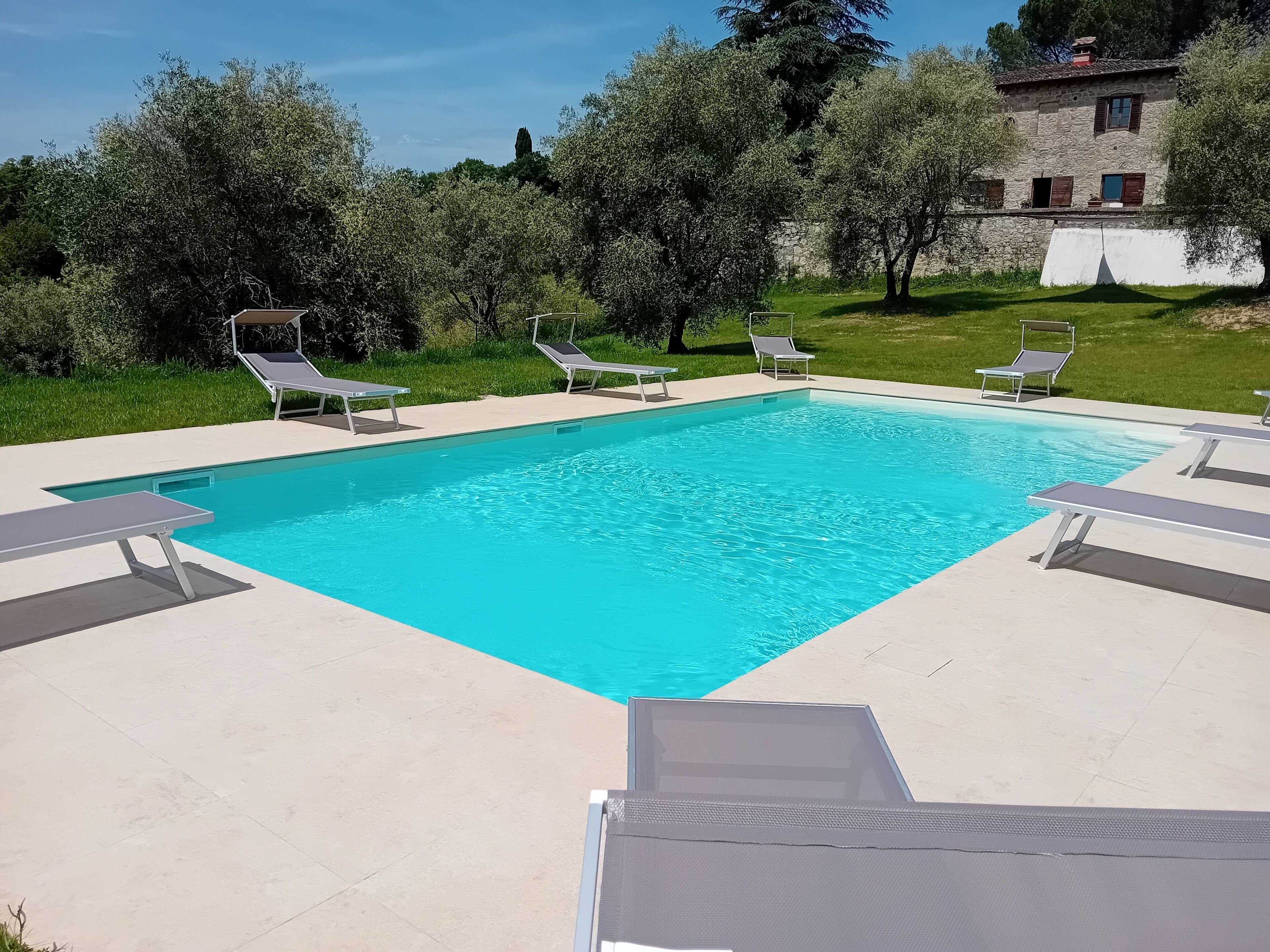 Een seizoensgebonden buitenzwembad, parasols voor strand/zwembad