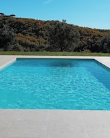 Una piscina al aire libre de temporada, sombrillas