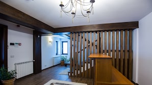 A spacious hallway with wooden flooring, a central wooden bench, and a chandelier. - Branmontecrai (Bran)