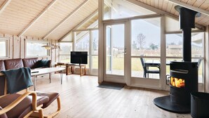 Un loft spazioso con soffitto alto, ampie finestre, un camino e un'accogliente zona salotto.