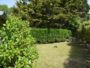 Stroll through the serene garden, surrounded by lush greenery and mature trees, with a play area for kids.