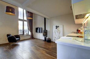 A modern interior with a fireplace, a flat-screen TV, and a large window with curtains.