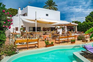 Un edificio blanco con terraza al aire libre y piscina.