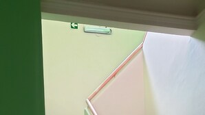 A staircase with green walls and a handrail.
