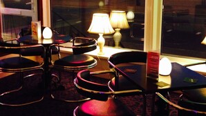 A dimly lit room with tables and chairs arranged for dining. - Belmont Hotel Blackpool (Blackpool)