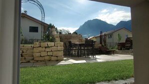 Une terrasse avec des murs en pierre, du mobilier d’extérieur et une vue sur les montagnes.