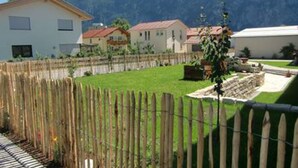 Un quartier résidentiel avec des maisons, une clôture en bois et une chaîne de montagnes en arrière-plan.