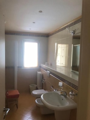 A bathroom with a toilet, bidet, sink, and a large mirror. - B&B Il Sogno (Montescaglioso)