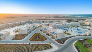 A resort with multiple buildings, a central pool area, and a view of the sea. - Pickalbatros Sea World Resort - Marsa Alam- "Aqua Park" - All inclusive (El Quseir)