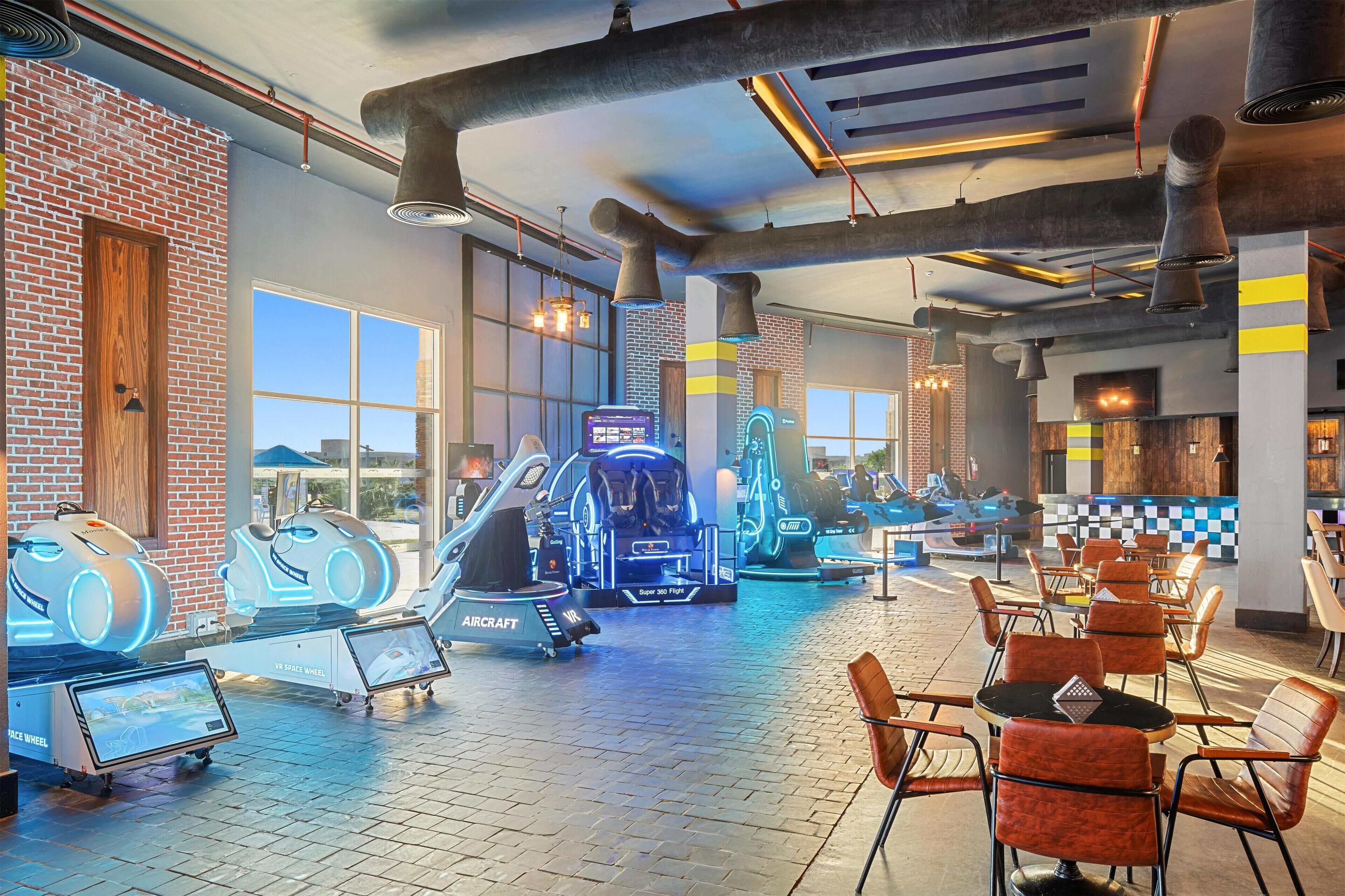 A gym with VR equipment, exercise machines, and seating areas.