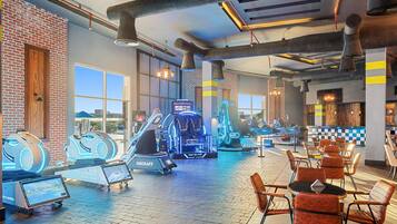 A gym with VR equipment, exercise machines, and seating areas.