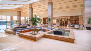A spacious lobby with high ceilings, large windows, and a central seating area with a water feature. - Pickalbatros Sea World Resort - Marsa Alam- "Aqua Park" - All inclusive (El Quseir)
