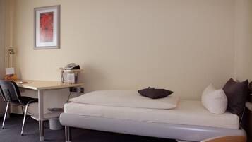 A small room with a bed, a desk, and a chair.