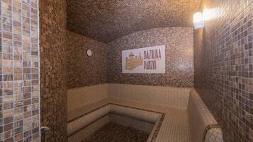 A tiled bathroom with a sign reading "BAZILIKA PANZIO".
