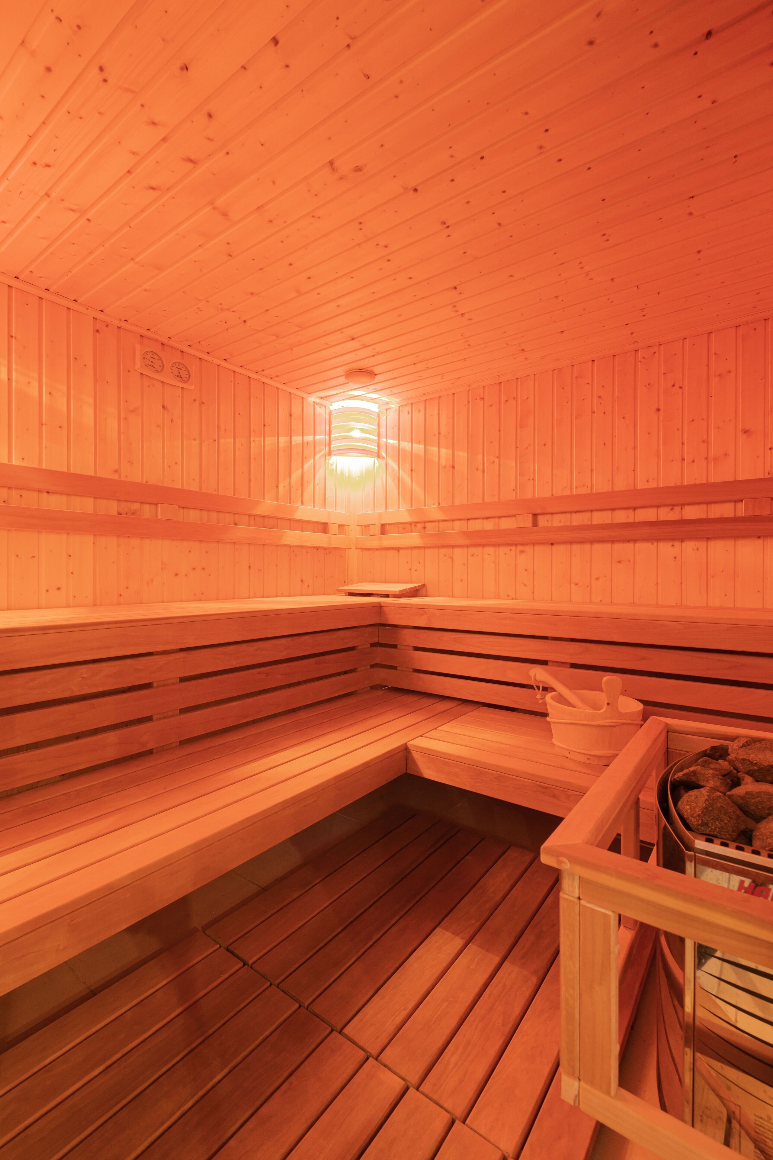 A sauna with wooden benches and a stone basin.