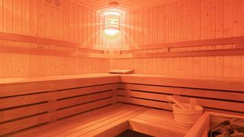 A sauna with wooden benches and a stone basin.