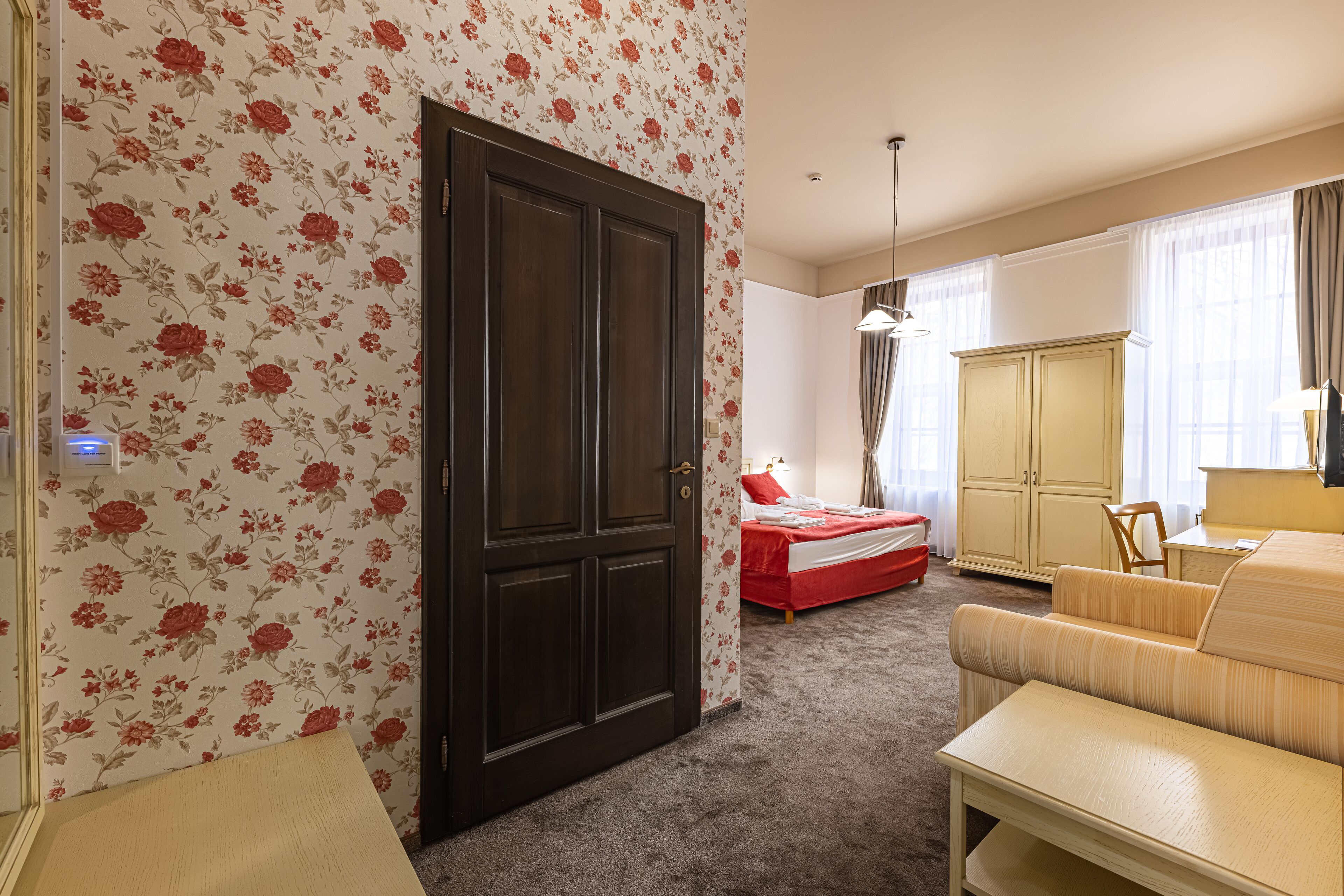A room with a bed, a sofa, a wardrobe, and a desk.