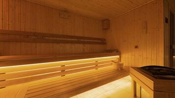 Uma sauna de madeira com bancos e um aquecedor central.