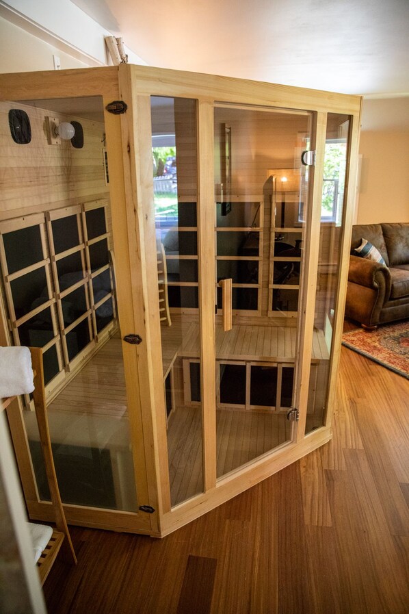 Un separador de ambientes de madera con varios paneles, una silla y un sofá en una sala de estar.