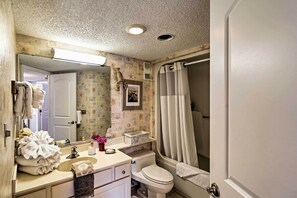 A bathroom with a sink, toilet, and shower curtain. - Pools, Patio & Stunning Views: Myrtle Beach Oasis (Myrtle Beach)