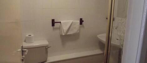 Un baño con inodoro, bañera y lavabo.