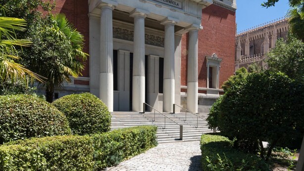 Un bâtiment à l’architecture classique, orné de colonnes et portant une inscription indiquant : « Real Academia Española ».