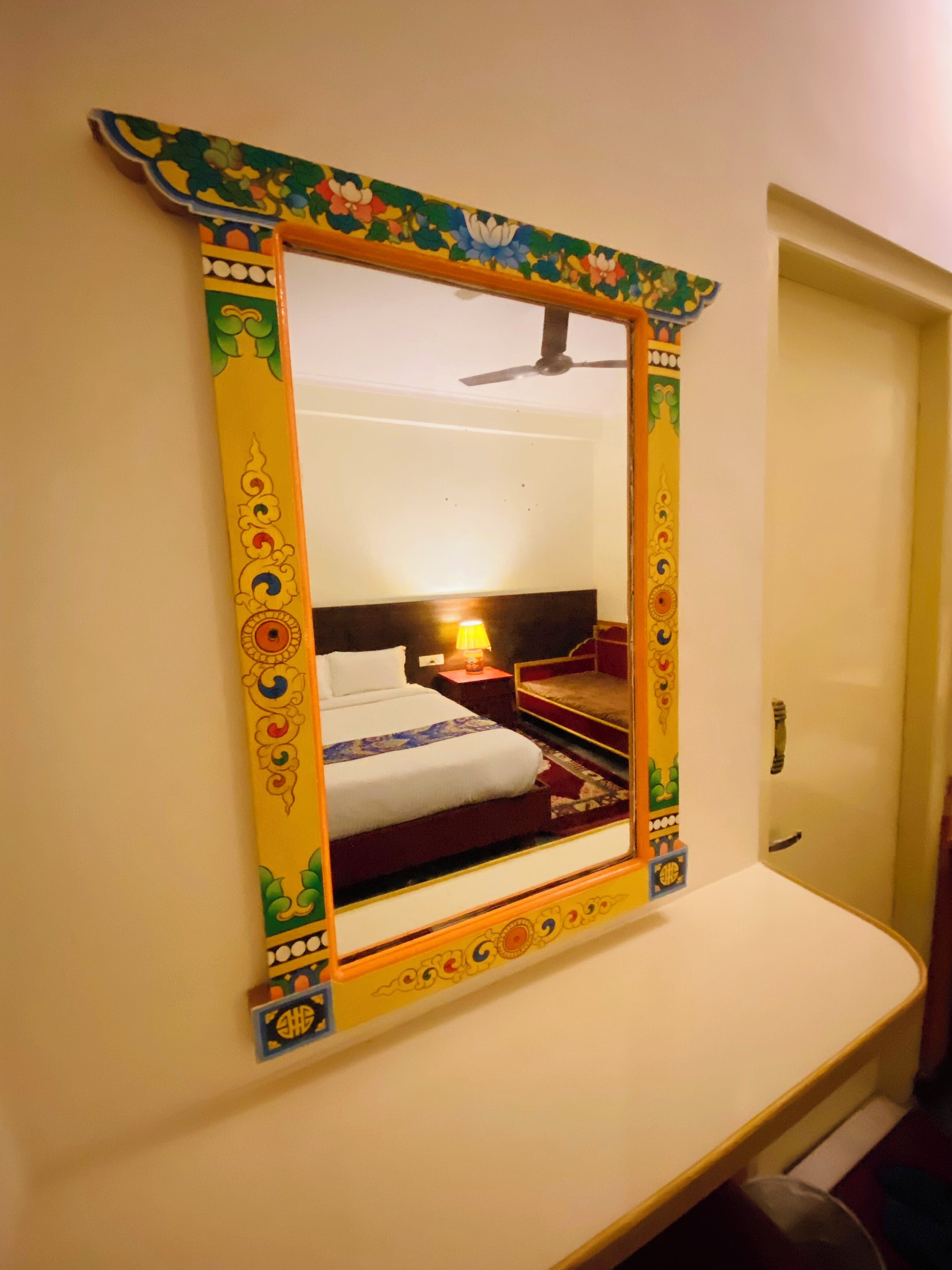 A room with a bed, a nightstand, a lamp, and a ceiling fan.
