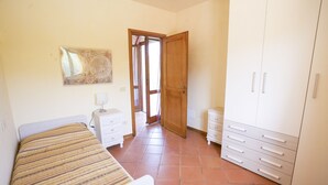 A bedroom with a bed, a dresser, a wardrobe, and a painting on the wall. - Villino Laura (Portoferraio)
