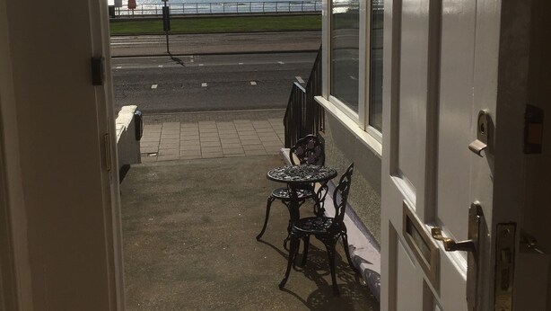 A doorway leading to a balcony with a view of the sea. - Adelphi Holiday Flats (Blackpool)