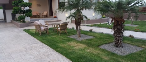 A modern house with a patio area featuring outdoor furniture and a well-maintained lawn.