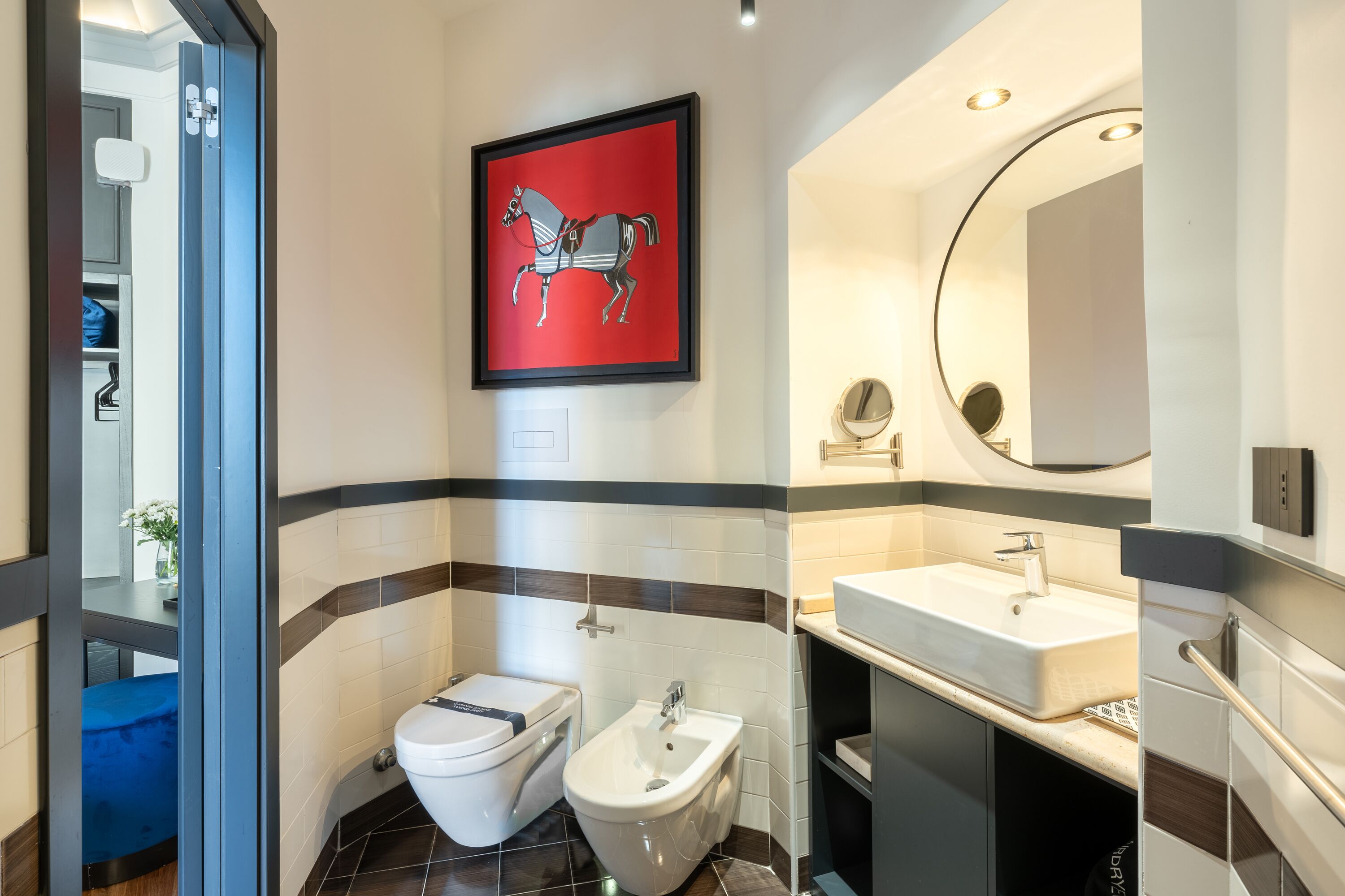 A modern bathroom with a toilet, bidet, and sink.