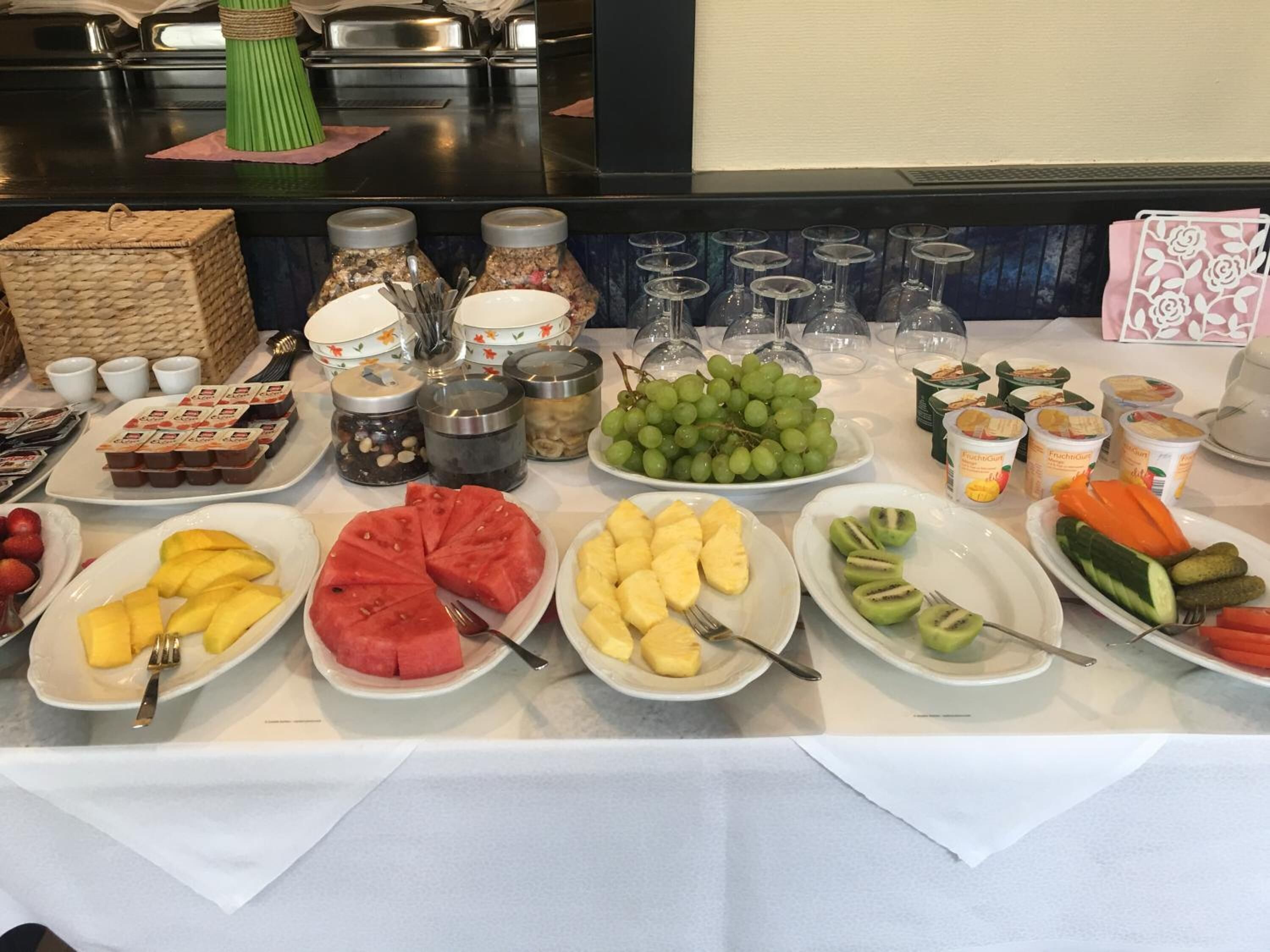 Un bufé con diversas frutas, yogur y aderezos.