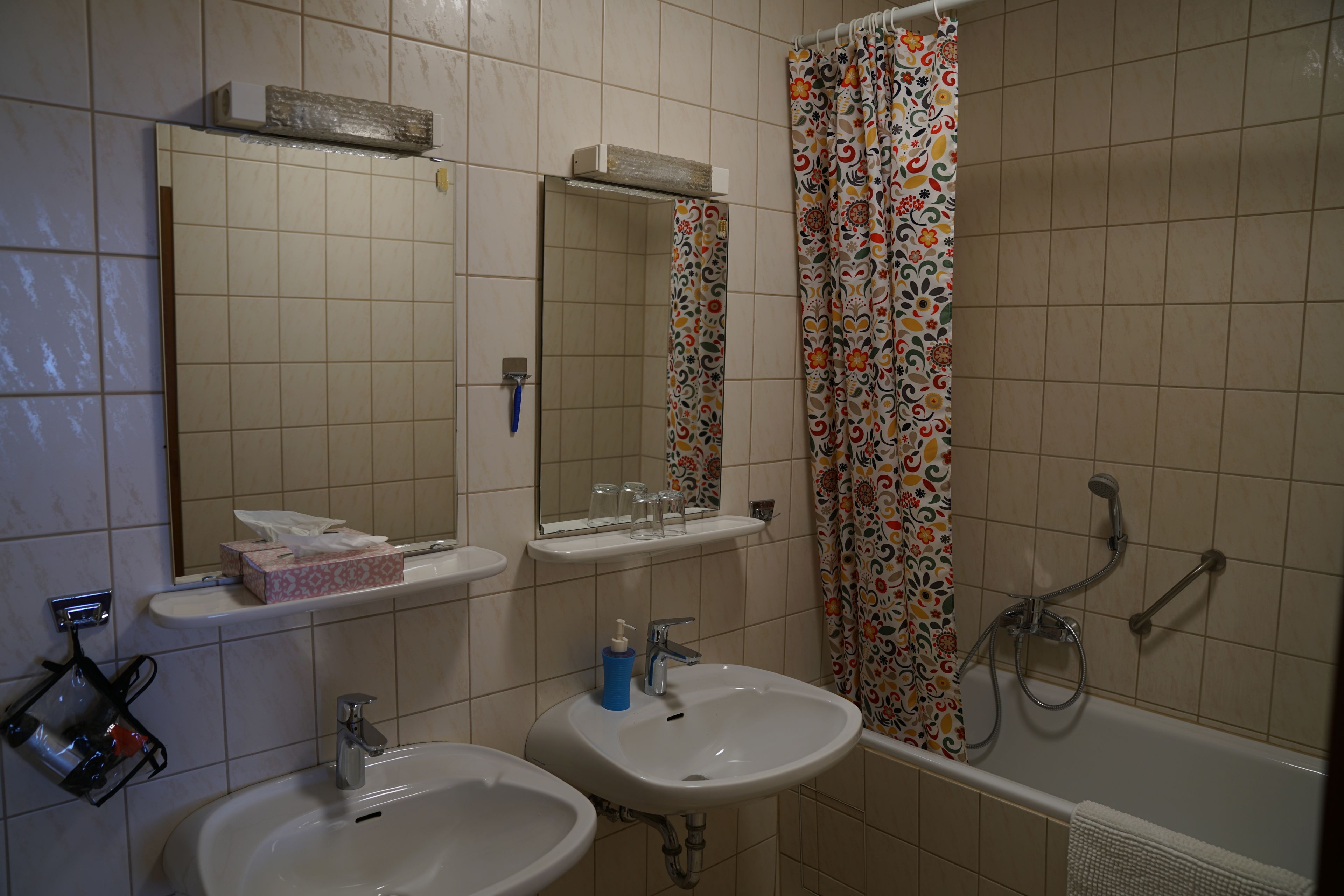 Une salle de bain avec deux lavabos, un miroir, une douche et des toilettes.