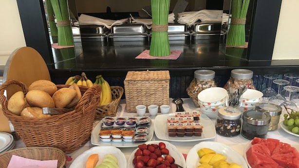 A buffet table with various food items including bread, fruits, and condiments. - Hotel Zum Grafen Hallermunt (Springe)