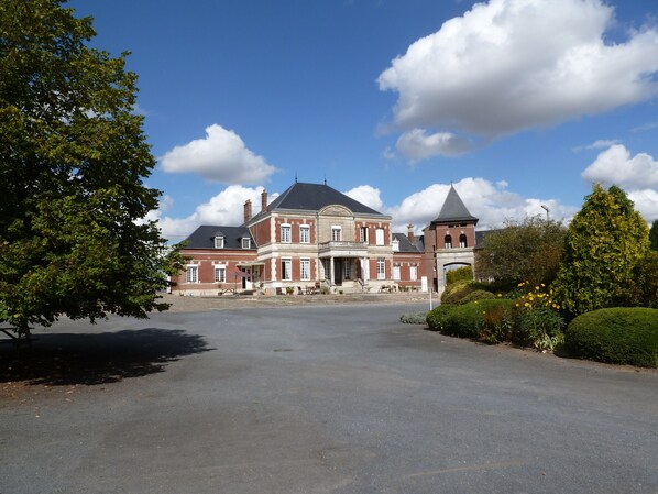 A large, historic building with a symmetrical facade, multiple chimneys, and a central entrance. - Ferme de Bonavis - Studios (Banteux)