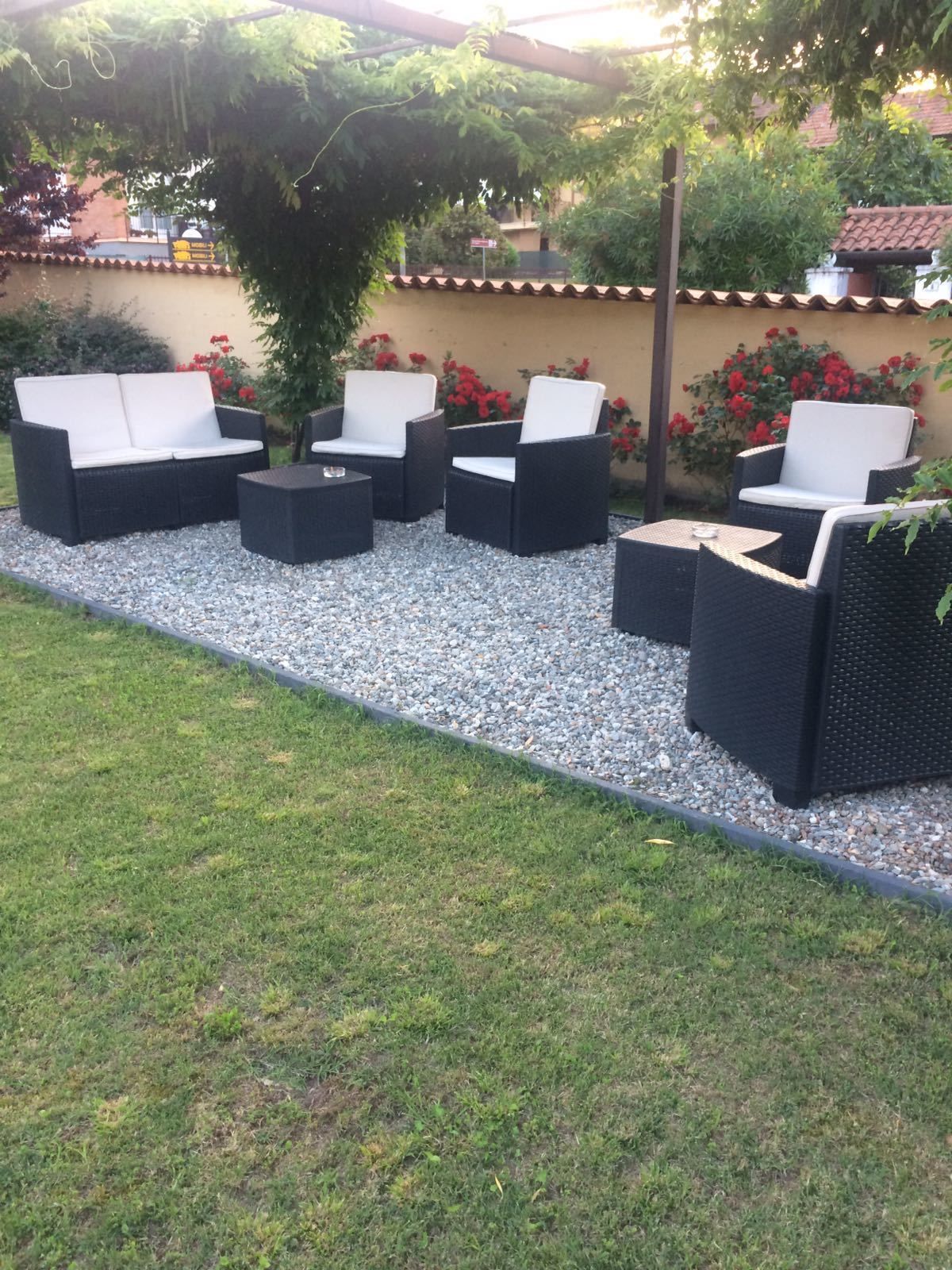 An outdoor seating area with wicker furniture and a gravel pathway.
