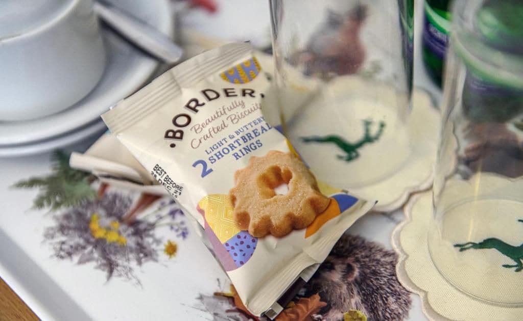 A packet of Border Shortbread Rings on a table with a floral tablecloth.