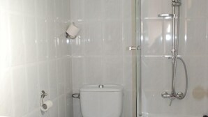 A bathroom with a toilet, a sink, and a bathtub. - Hostal Delgado (Benabarre)