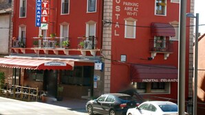 A red building with a sign for 'Hostal Delgado' and 'Hostal Restaurant Pizzeria'. - Hostal Delgado (Benabarre)