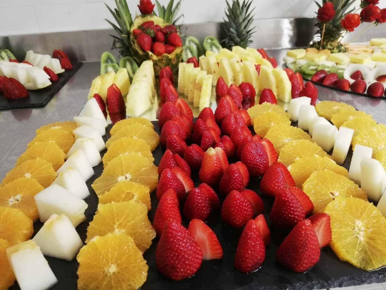 A fruit platter with strawberries, oranges, and pineapple slices.