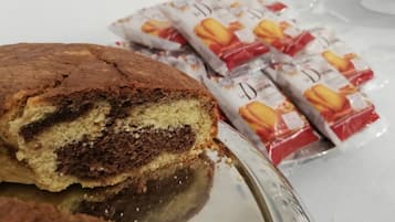 Ein Stück Kuchen mit Schichten aus Schokolade und Sahne, im Hintergrund Päckchen mit La Dorne Schokoladenkeksen.