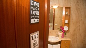 A wooden door with two motivational signs: "LIVE with LOVE in your HEART" and "LIVE IN THE MOMENT".