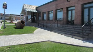 A building with a brick facade, large windows, and a covered entrance.