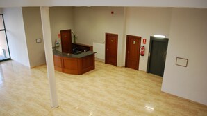 A spacious room with a kitchen area, a large window, and a door leading to another room.