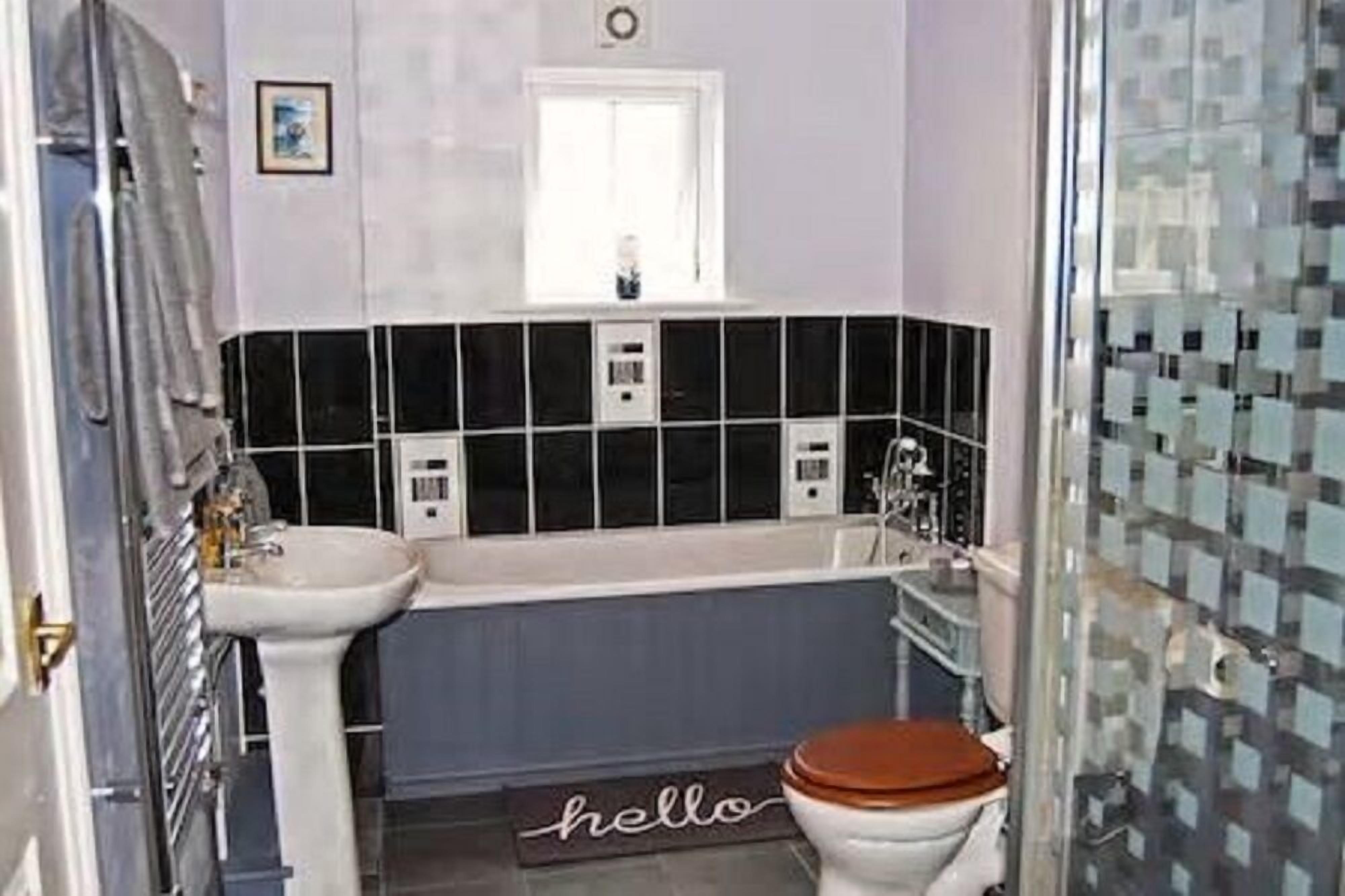 A compact bathroom with a white sink, a bathtub, and a toilet.