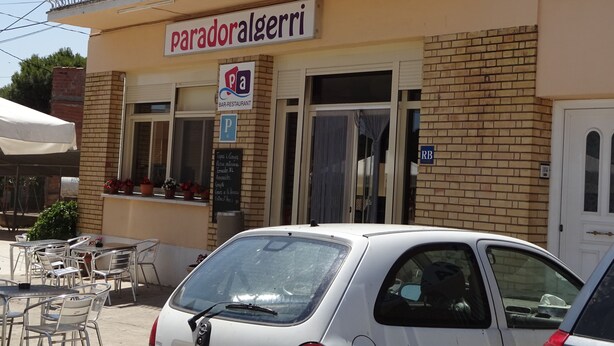 A restaurant named 'paradoralgerri' with outdoor seating and a parking sign. - Hostal Terraferma (Algerri)